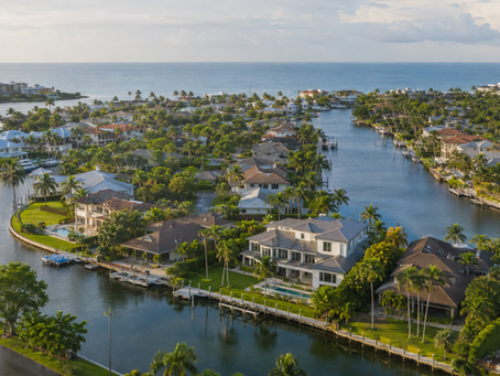 Aerial view of Naples waterfront homes, canals, docks and seawalls illustrating flood map and elevation due diligence for luxury real estate investors.