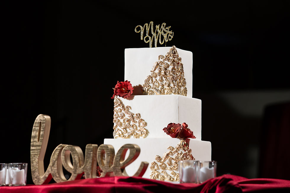 Elegant wedding cake with gold and red accents during the wedding reception at Martin's Crosswinds in Greenbelt, Maryland.