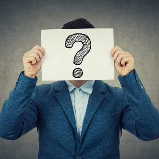 Een man met een papier met een vraagteken erop voor zijn hoofd