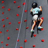 Niño escalando pared de rocódromo.png