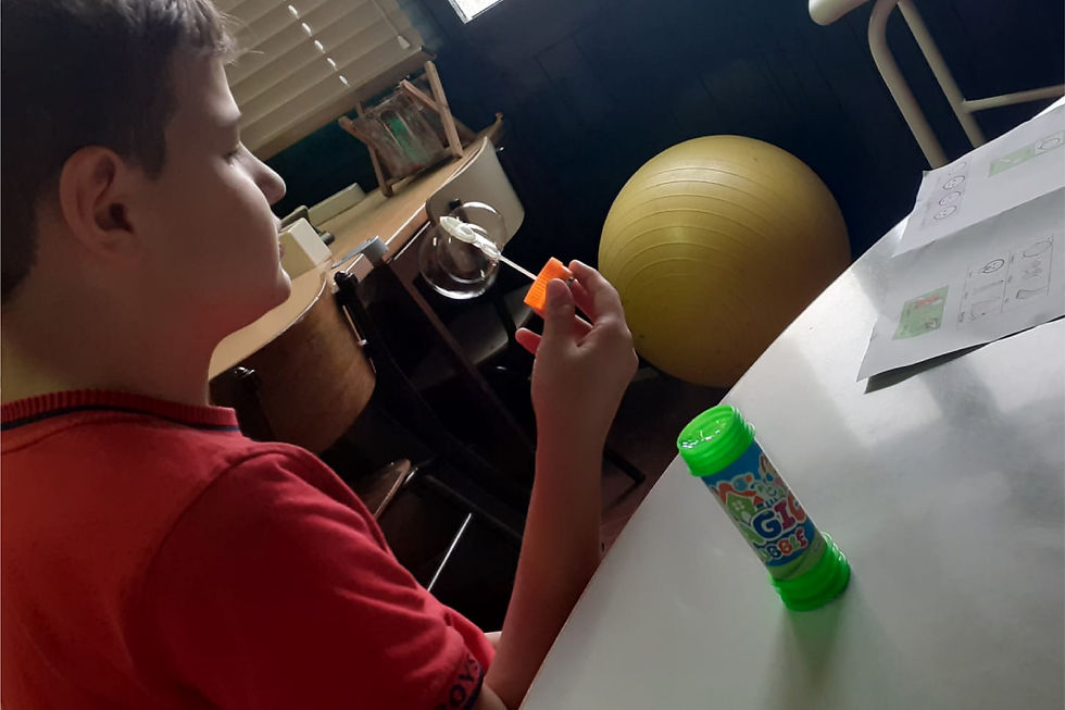Menino a soprar bolhas de sabão numa atividade do projeto Para Além Barreiras