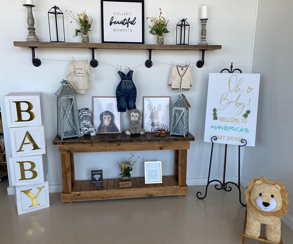 Welcome Guests display featuring a clothesline of baby clothes, large oversized blocks spelling BABY and stuffed lion and signage welcoming guest