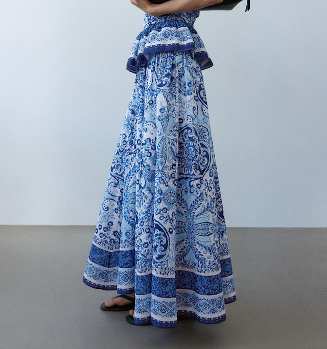 Laura Blair wearing a blue and white H&M co-ord with a strapless paisley-print bandeau top and matching maxi skirt, styled with nude strappy heels for a summer occasion outfit.