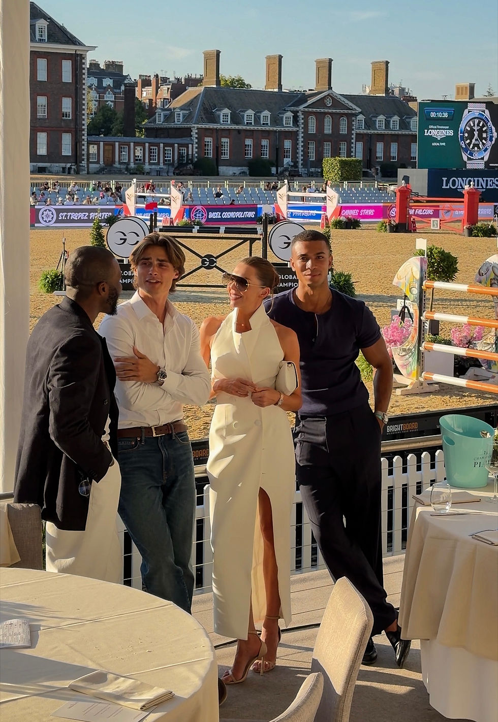 Laura Blair attending the Longines Global Champions Tour in Chelsea as a guest of Longines, wearing a white waistcoat style backless summer dress and the Longines Mini DolceVita Quartz watch in stainless steel with an 18 karat yellow gold crown, alongside images of the show jumping, elegant outdoor dining, food, drinks and quintessential British summer atmosphere.