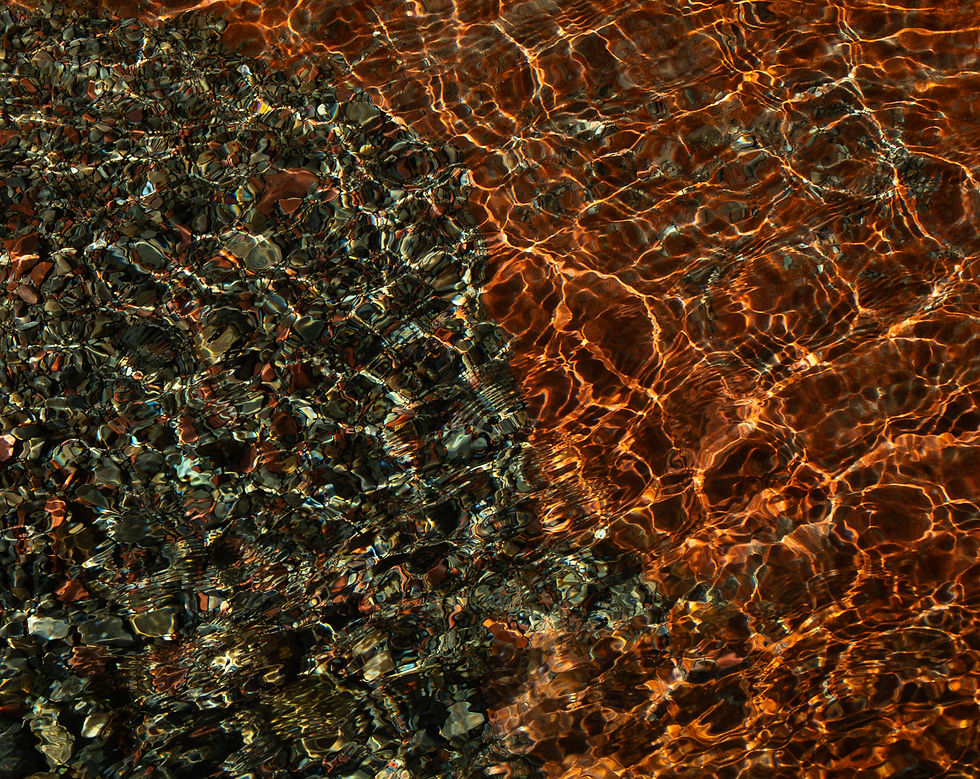 abstract photo of water with a sunlight reflection. half of the water is red and the other is a mixture of colour