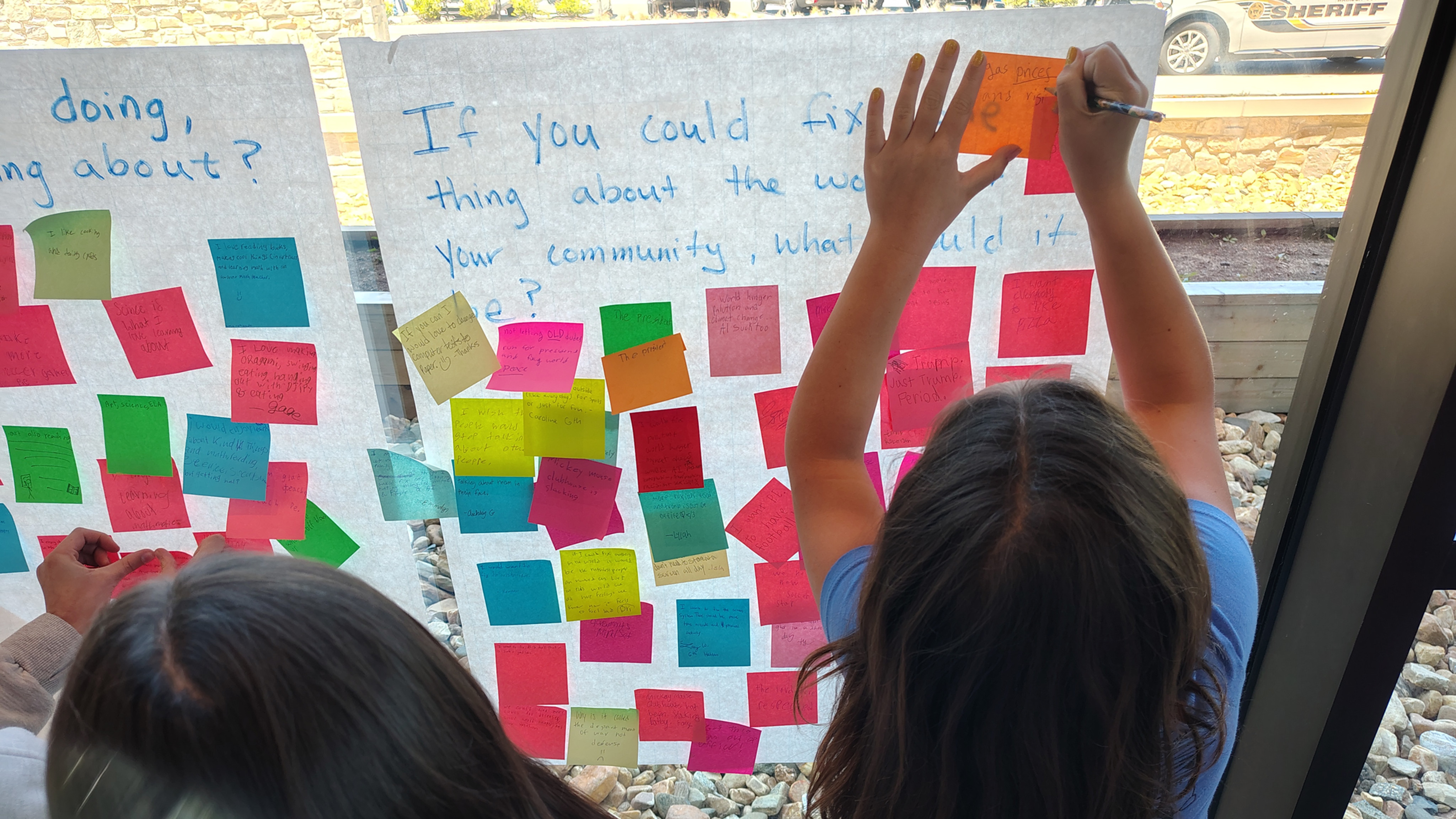 Students writing their ideas on sticky notes. 