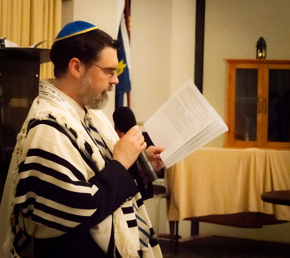 Rabbi in tallit reciting liturgy from a siddur