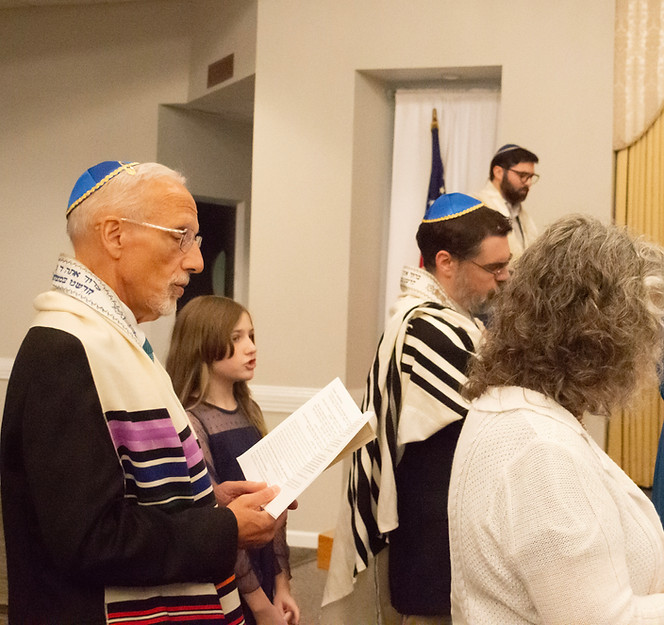 Congregants in kippot and tallits praying at a Shabbat service in Raleigh-Durham NC
