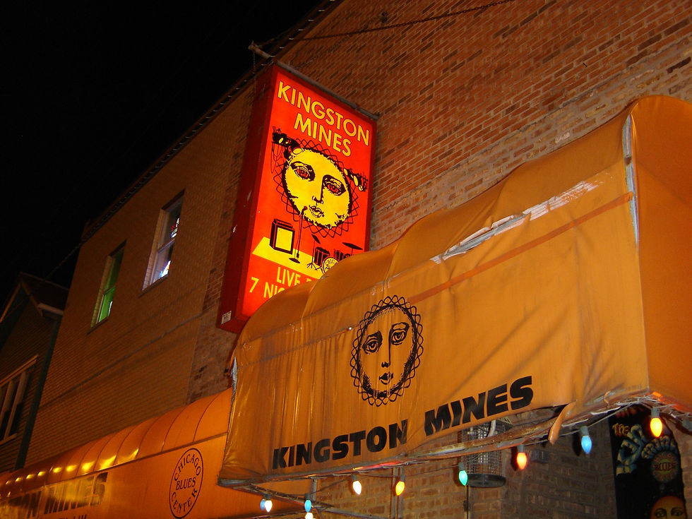 High angle view of a dimly lit blues club stage with microphone and guitar