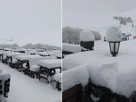 Karla kaplı masa ve sandalyeler, sisli bir dağ manzarasında. Karla kaplı lambalar. Sessiz ve huzurlu kış ortamı.