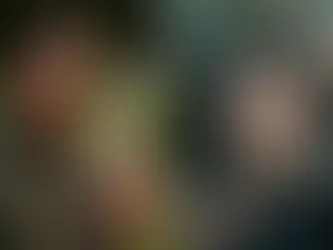 İki adam karşı karşıya. Soldaki çizgili takım elbise ve güneş gözlüğü takıyor, silah tutuyor. Sağdaki adama silahlar doğrultulmuş. Gergin atmosfer.