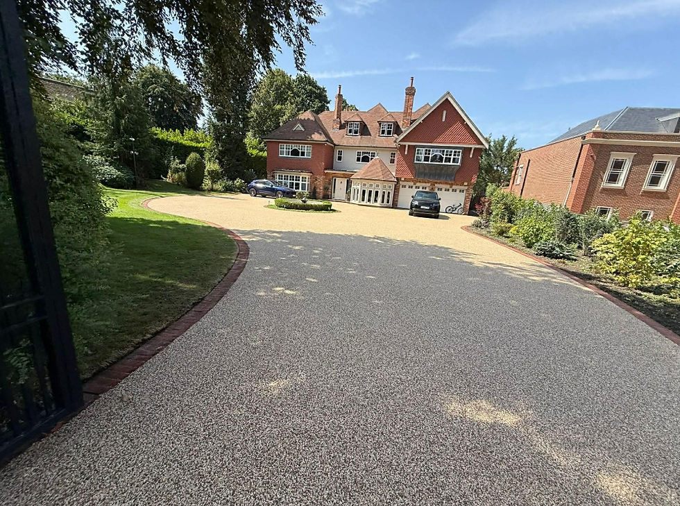 Red brick house with large gravel driveway and cars