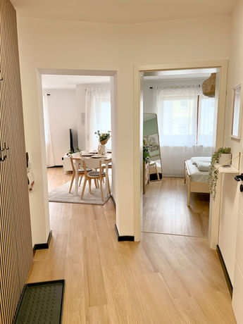 Langer Flur mit Holzboden, Blick auf Essbereich mit Stühlen und helle Räume im Boho-Stil