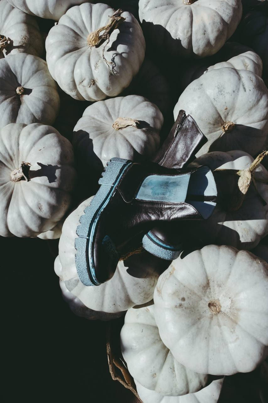 Жіночі шкіряні черевики з бірюзовою підошвою на фоні гарбузів