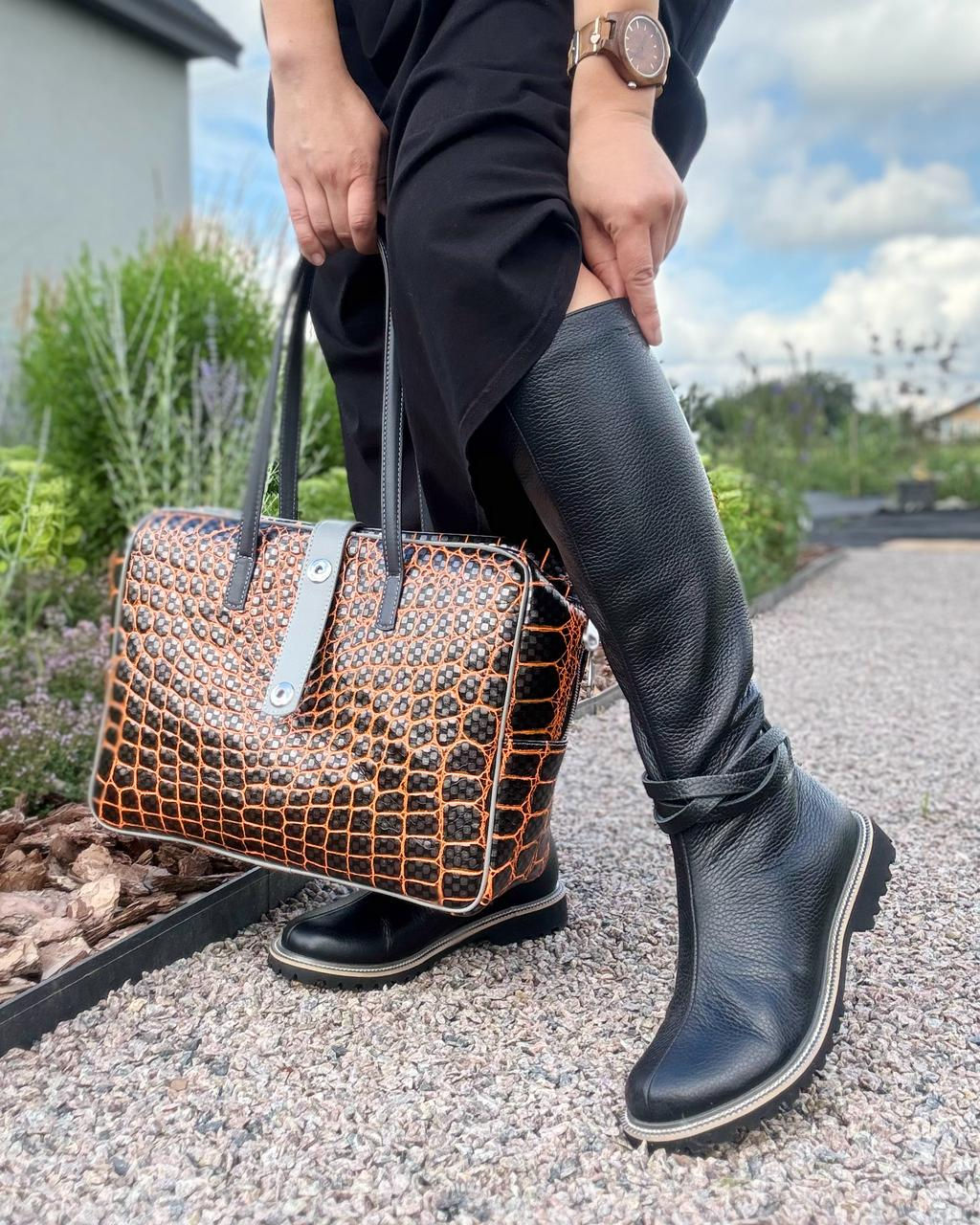Жіночі чорні шкіряні чоботи з ремінцем і сумка з тисненням під рептилію, зйомка на вулиці