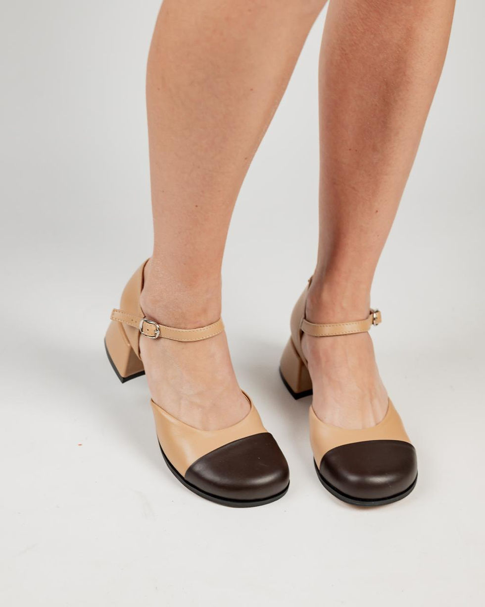 Жіночі шкіряні туфлі Мері Джейн бежевого кольору з темно-коричневим носком на ногах.