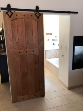 Custom wooden barn door with black hardware.by Narrow Leaf Woodworks in Albuquerque 
