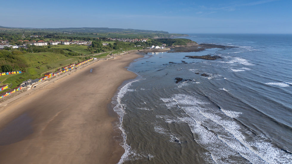 Eye-level view of Scarborough beach with calm waves and sandy shore