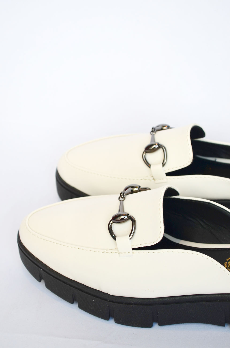 Miniatura: Mocasín destalonado tipo mule en color latte con hebilla y suela chunky.