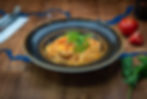 A bowl of pasta garnished with rocket