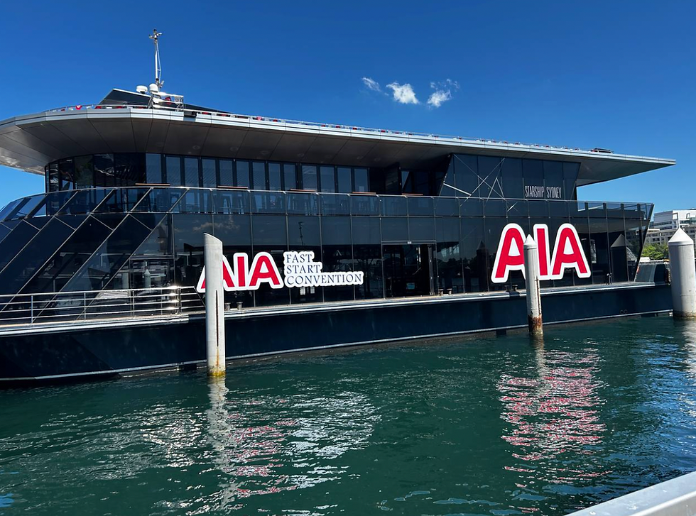 Starship Sydney at the marina with full-scale AIA event branding visible on exterior windows.