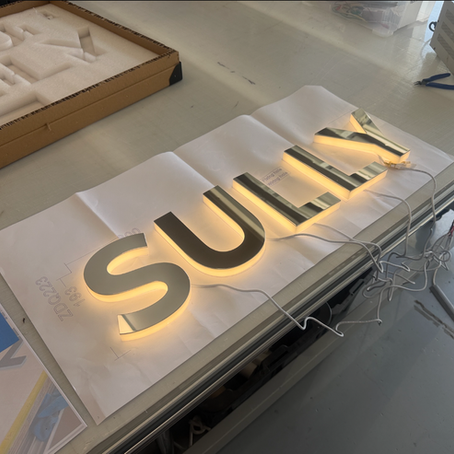 Finished illuminated “SULLY” signage glowing at night on luxury vessel at Trinity Point marina.