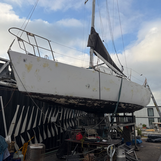 Marine vinyl installation in progress on Hick 35 exterior hull at marina