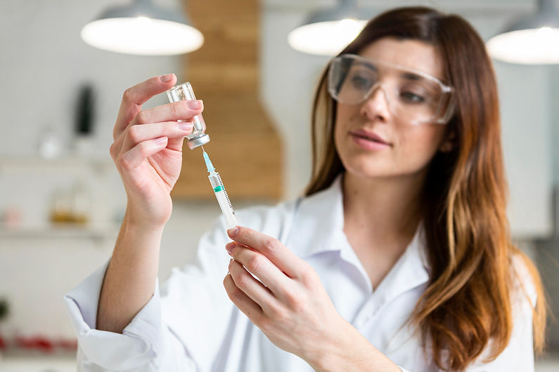 female-scientist-with-safety-glasses-holding-syringe-with-vaccine-lab.jpg