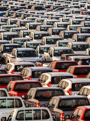 Pátio com automóveis e comerciais leves estacionados lado a lado, representando o volume de veículos novos disponíveis para venda no Brasil.