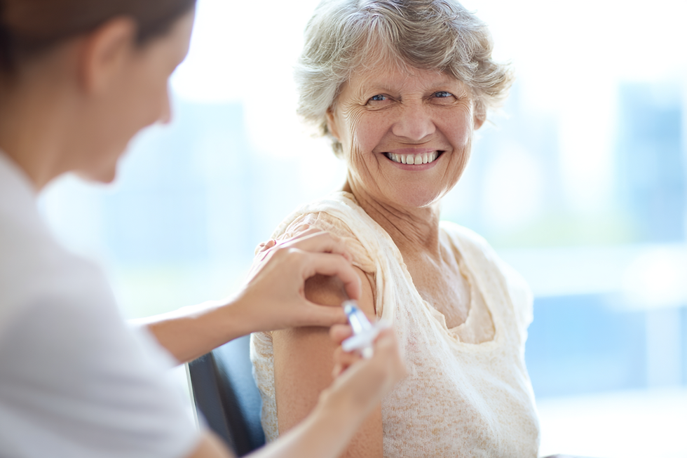 Femme âgée souriante recevant une injection lors d’une vaccination.
