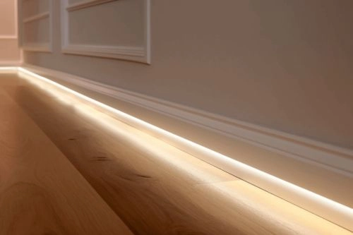 Couloir élégant équipé de plinthes LED au sol, facilitant les déplacements nocturnes pour les personnes âgées ou à mobilité réduite.