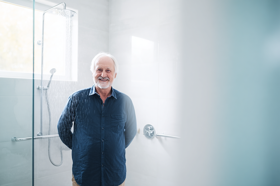 Homme senior souriant dans une douche adaptée PMR sécurisée