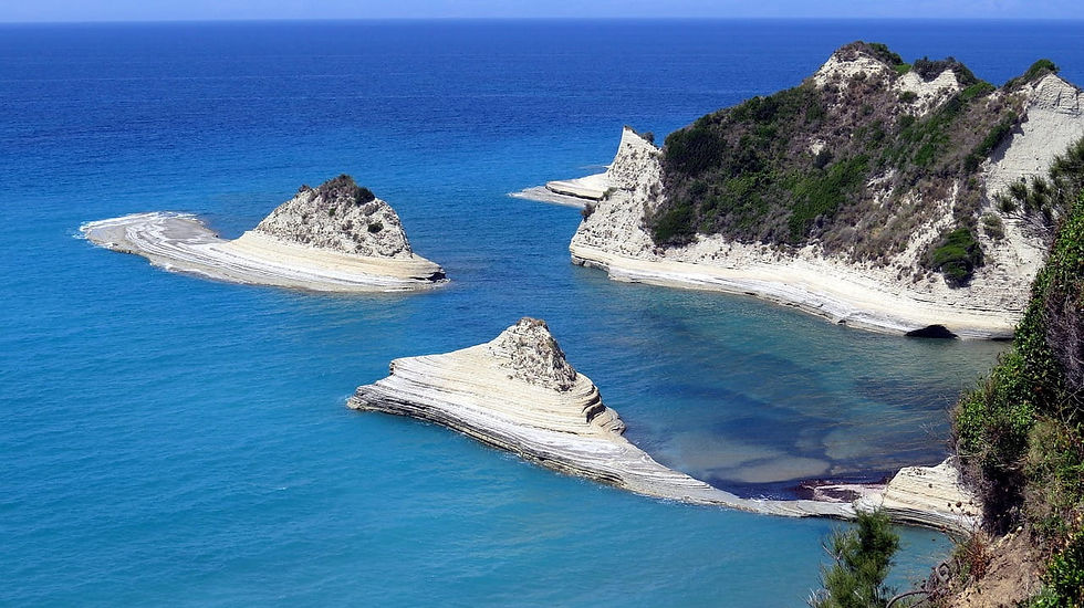 Blaues Meer mit geschichteten weißen Felsinseln und Klippen, ruhige Küstenlandschaft ohne Menschen auf Korfu.
