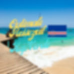 Holzsteg am Strand von Kap Verde. Text "Optimale Reisezeit Kap Verde" und Kap-Verde-Flagge. Blaues Meer, Boote, sonnig, entspannte Stimmung.