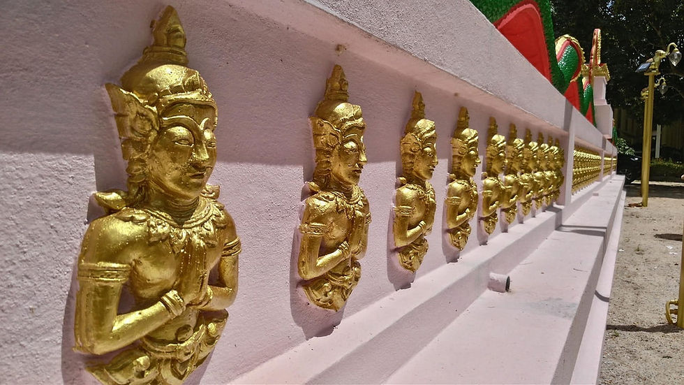 Reihe goldener Figuren mit gefalteten Händen an rosa Wand, draußen bei Sonnenlicht. Grün-rotes Muster im Hintergrund. Friedliche Atmosphäre. Reiseziel Koh Samui, Thailand