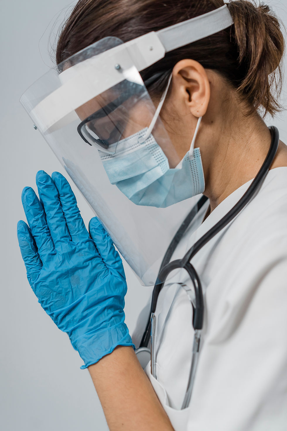 side-view-female-doctor-with-medical-mask-face-shield-praying.jpg