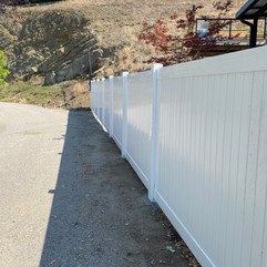 white vinyl fence separates a commercial property in vernon bc and a residence