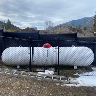 black chainlink safety fence built to house a large white propane tank in vernon bc by blue rhino fence