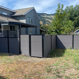 a glavanized sheet metal fence with black 2.5 inch square posts at a north okanagan residential property