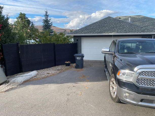 corrugated metal fence with black metal posts creates privacy for a residence in vernon bc