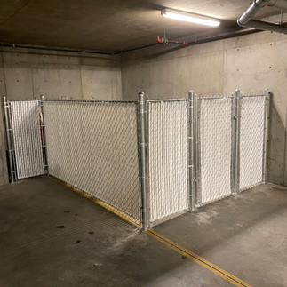 indoor chain link privacy compound with white privacy slats build by commercial fence builder in vernon bc