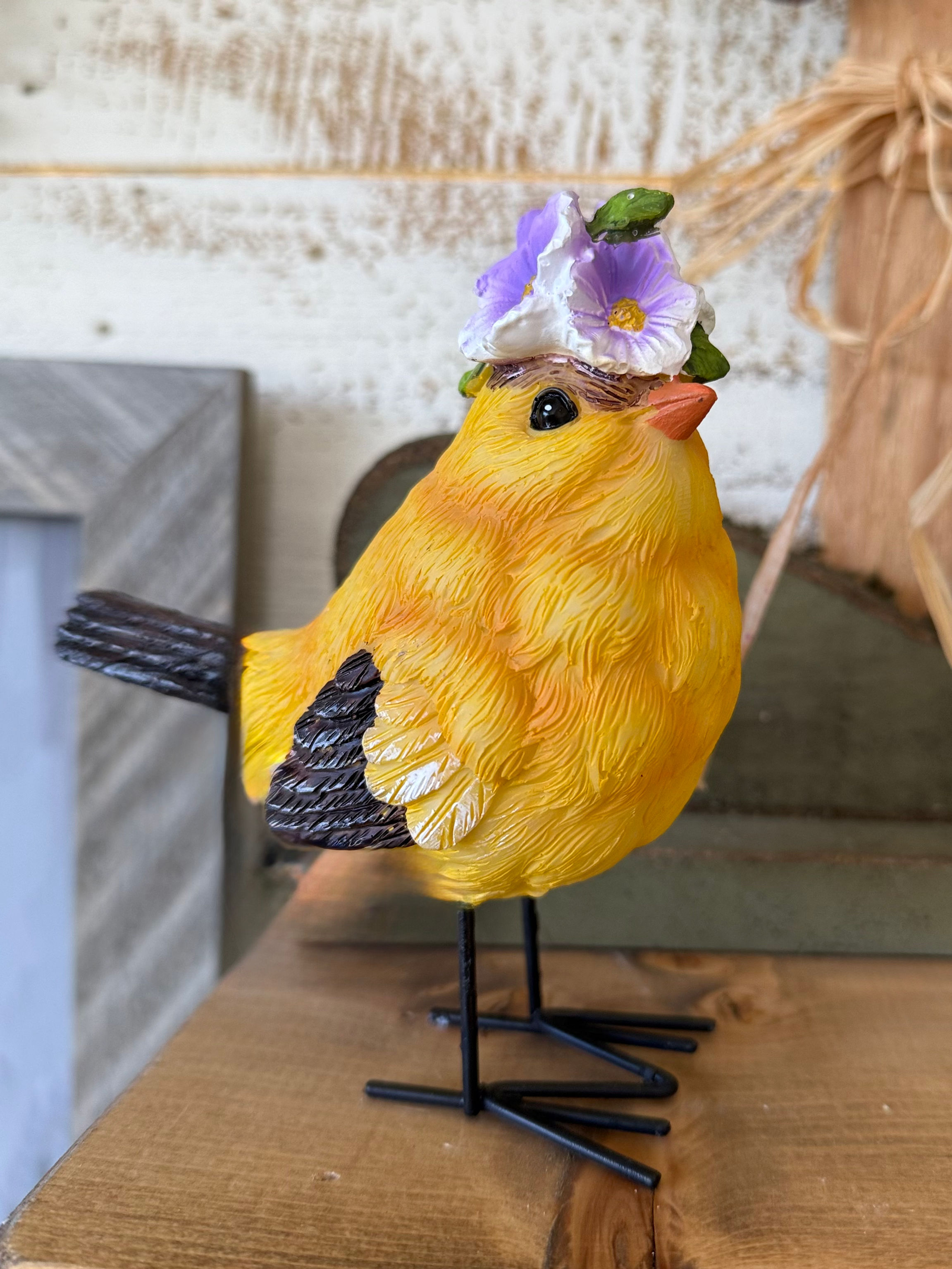 4.75" x 4" resin bird, yellow & black, wearing a purple flower crown, black metal legs & feet