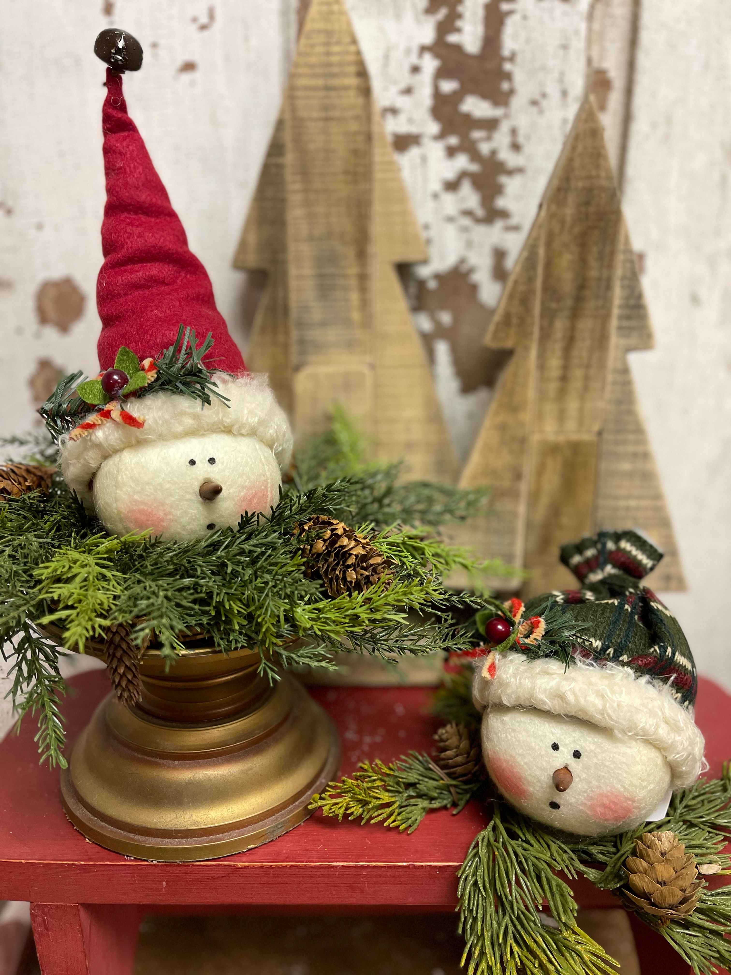 Set of 2 plush snowman heads wearing a Santa hat and a sock cap. Use as ornaments or bowl fillers.Great stocking stuffer gift