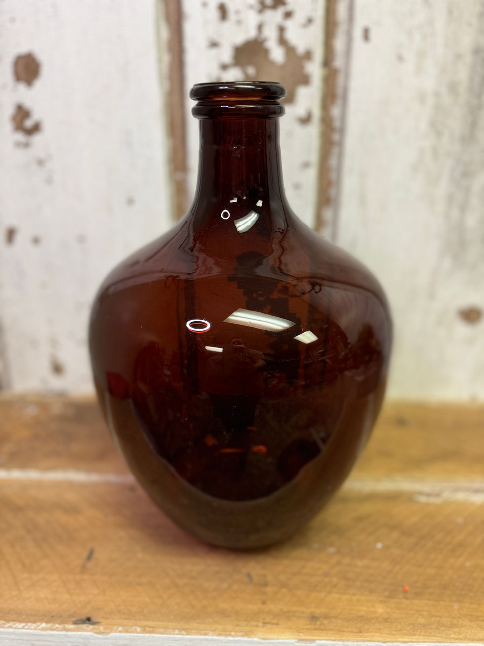 13" tall x 8" diameter glass bottle with narrow neck, amber colored