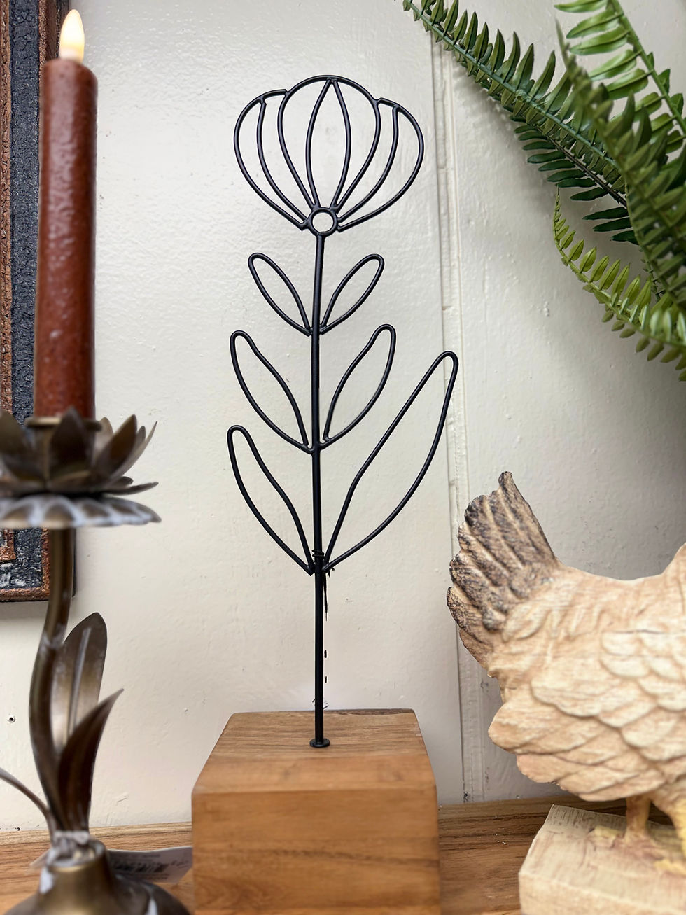 4" x 16" black metal wire sculpture of flower on stem, freestanding on wood block