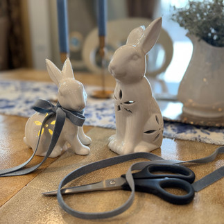 2 white porcelain bunnies with blue velvet ribbon