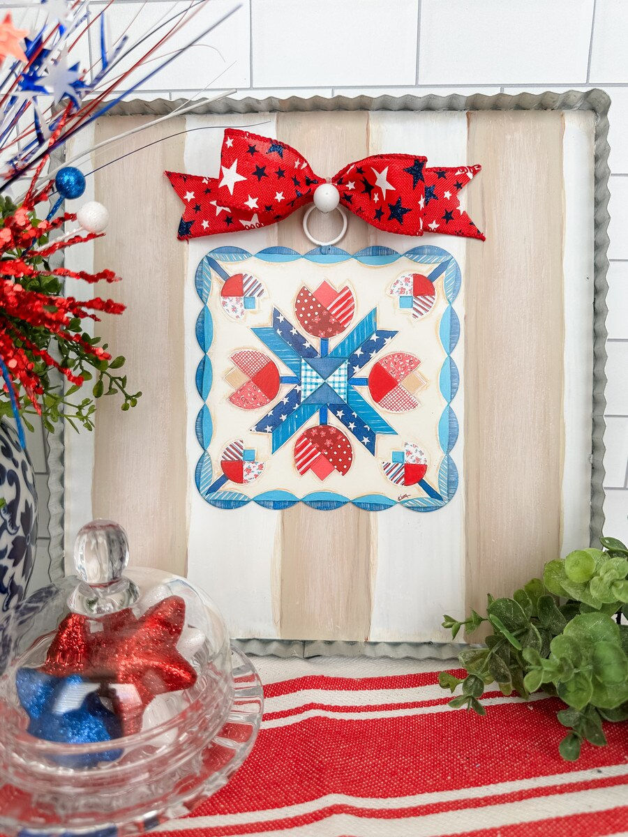 6" x .5" x 7" Round Top Collection metal square with scalloped edges printed with a red, white and blue quilt block design