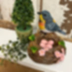 4.25" x 4.25" Resin figurine of a blue bird sitting on a nest with 4 pink eggs inside