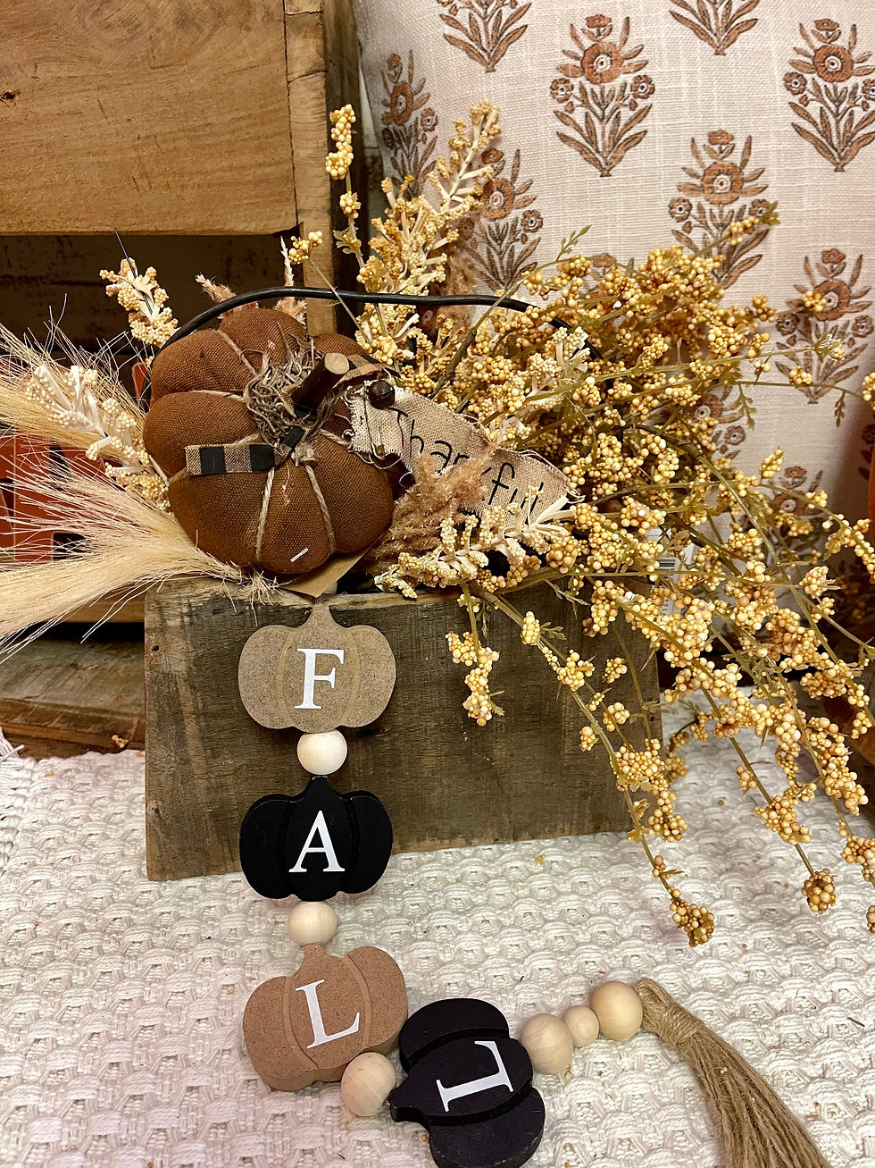 2.5” x 20” long, flat wood pumpkins & wood beads strung on jute rope with jute tassel, black & brown pumpkins spell out FALL