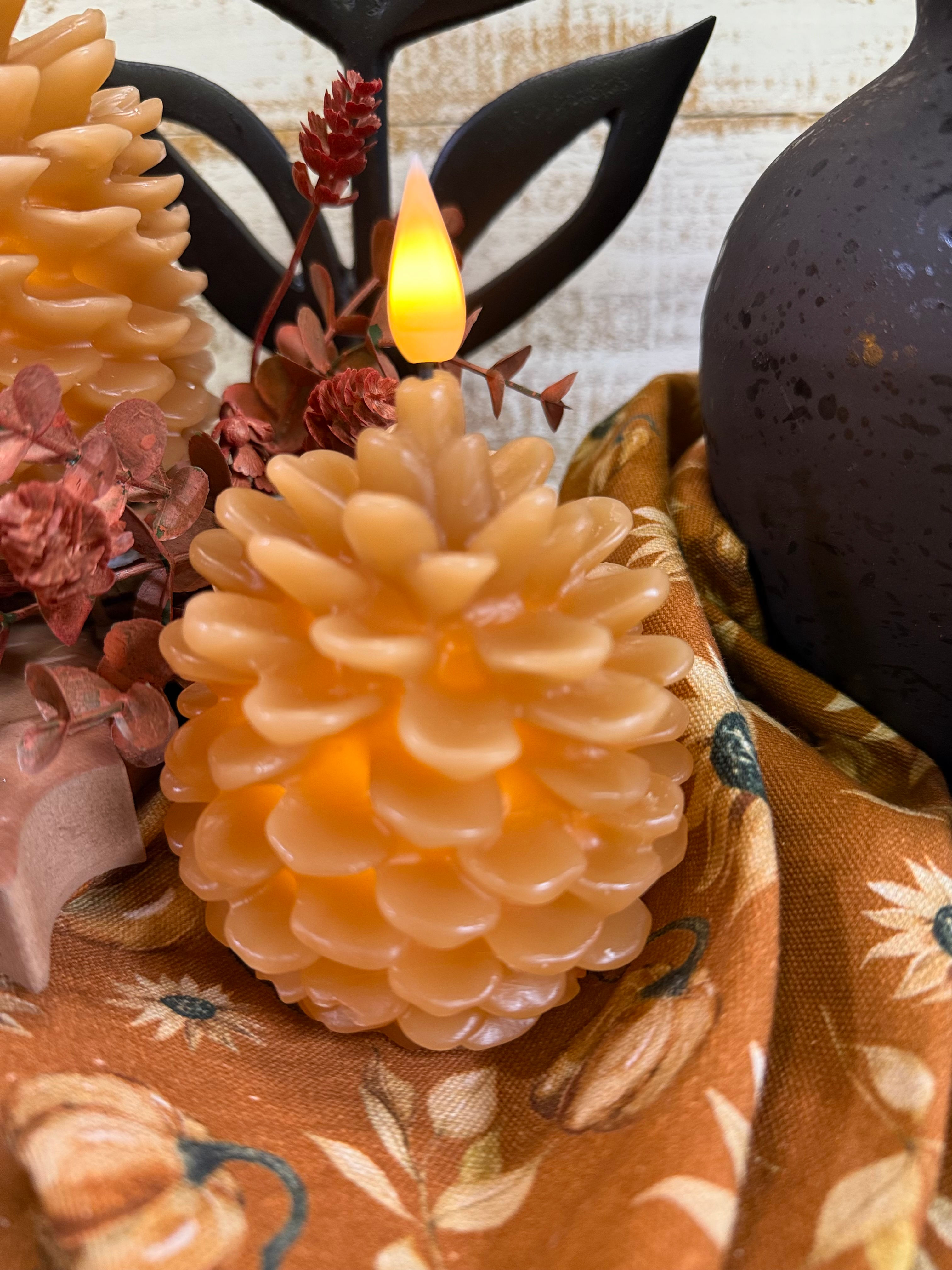 3" x 5" caramel colored wax candle, pine cone shaped, 6 hour automatic timer, uses included disc battery, fall decor